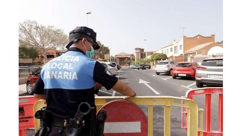 Un agente de policía coloca una valla para prohibir el paso al hotel situado en el municipio tinerfeño de Adeje, en el que se hospedaba el turista italiano que ha dado positivo por coronavirus de Wuhan ( EFE/Ramón de la Rocha)